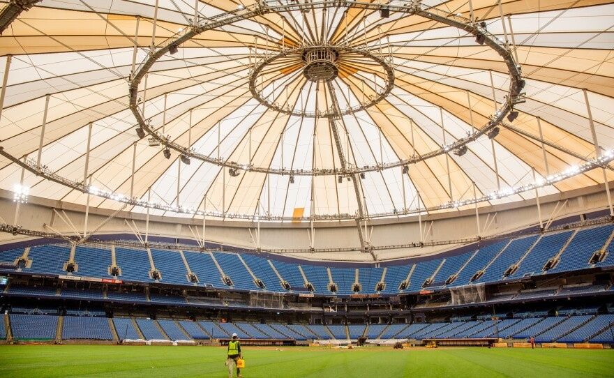 Innenansicht eines Fußballstadions mit steilen blauen Tribünen und Spielfeld
